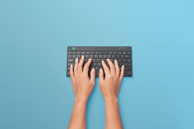 Vrouwenhanden typen op ergonomisch toetsenbord